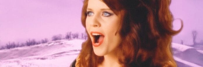 A banda The B-52's cantando com roupas coloridas no videoclipe da música Roam em 1989.