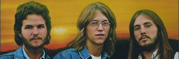 Os três integrantes da banda America jovens com cabelos compridos no início dos anos 70.