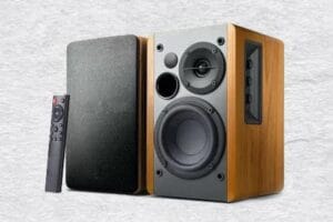 Caixa de Som Madeira Vintage – Curadoria Eu Vivo no Repeat Caixa de som acústica com acabamento clássico em madeira e design vintage, reproduzindo áudio de alta fidelidade.