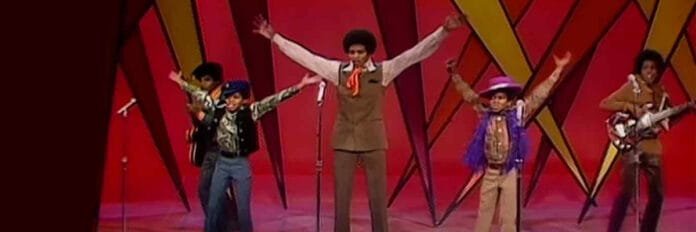 A aposta do produtor Berry Gordy que mudou a história do pop. Os cinco irmãos do Jackson 5 sorrindo enquanto se apresentam no palco na época da gravadora Motown no final dos anos 60.