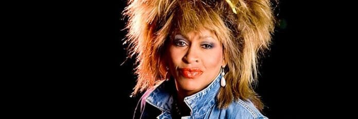 Tina Turner com jaqueta jeans e cabelo volumoso no clipe oficial de 1984.